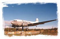 A historic  Canadian Pacific Airlines DC-3 passenger plane is mounted so perfectly on 
a pedestal at the Whitehorse International Airport that the slightest breeze causes it to swing around to point into the wind.